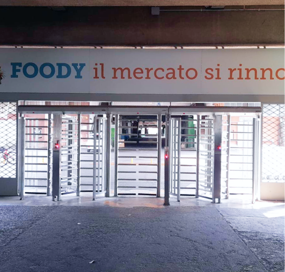 Ingresso pedonale del Palazzo Affari del Mercato Agroalimentare di Milano con la scritta “Foody il mercato si rinnova”