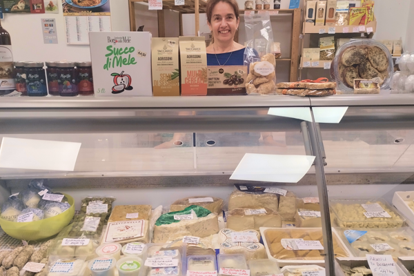 Banco alimentare con prodotti freschi e confezionati e persona dietro il bancone