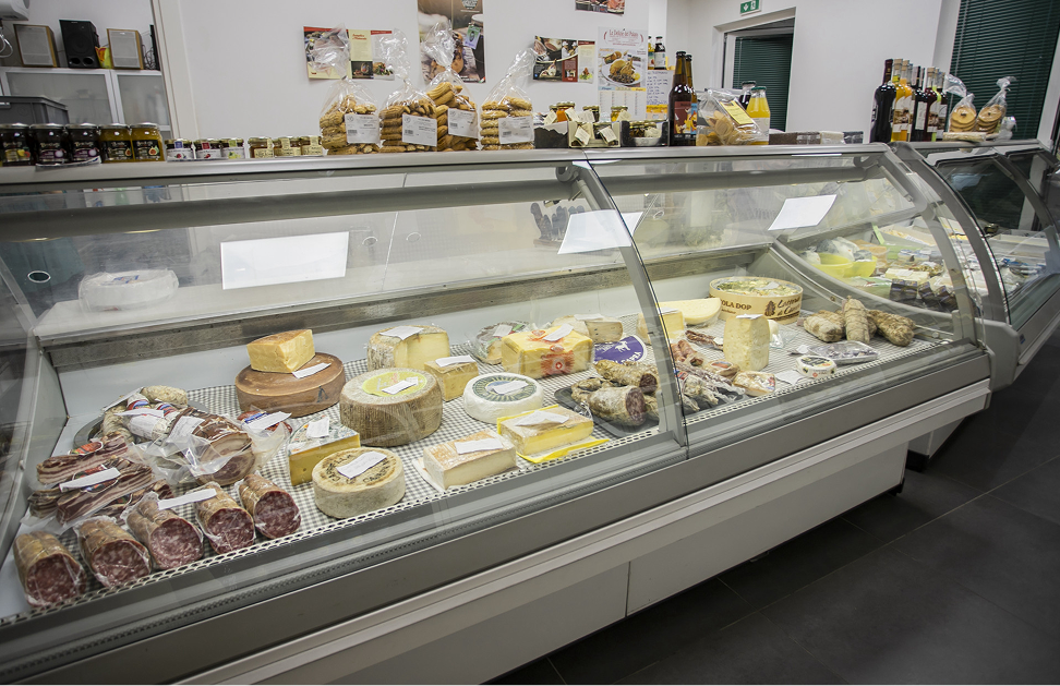 Banco frigorifero con formaggi e salumi in esposizione in un punto vendita del mercato